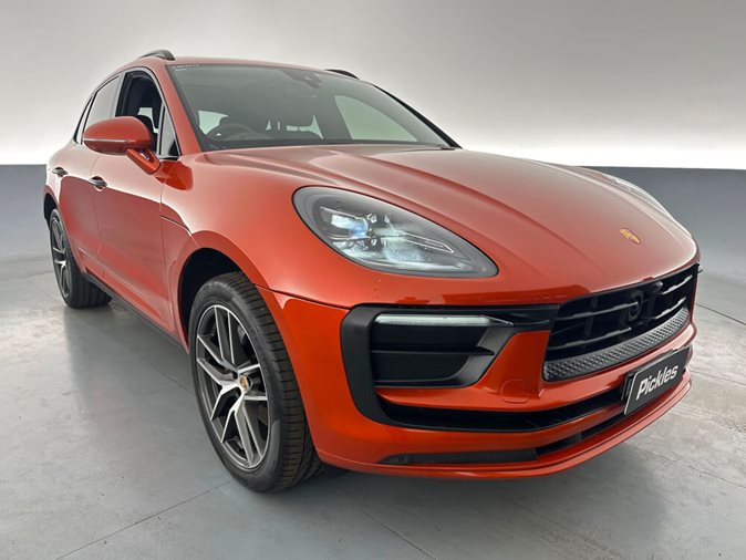 View an orange 2022 Porsche Macan available via auction.